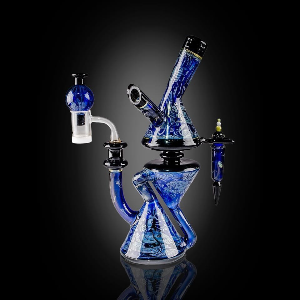 Blue-and-white patterned glass recycler by Robert Mickelsen, with a cone base, an angled neck, a bubble top and a quartz banger, photographed on black