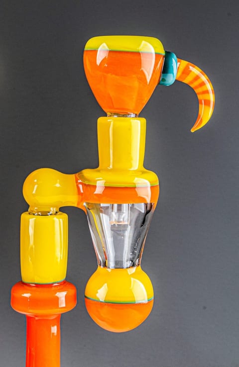 Close-up of the orange and yellow glass rig by Robert Mickelsen: the curled horn, the mouthpiece and the joint