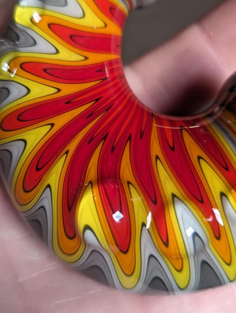 Detail of a fan-worked glass piece in red, yellow and grey
