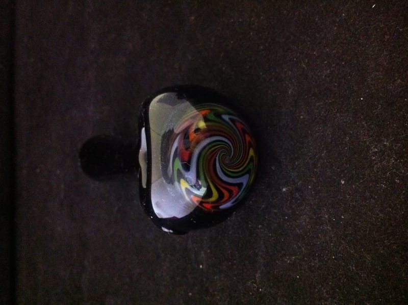 Close-up of a hand pipe bowl with a rainbow swirl worked into the glass