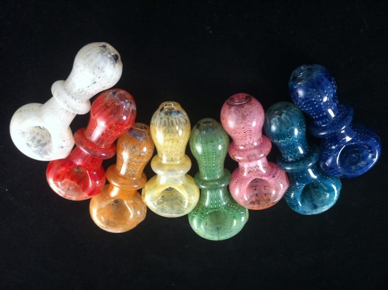 Eight small hand pipes lined up in white, red, amber, green, pink and teal