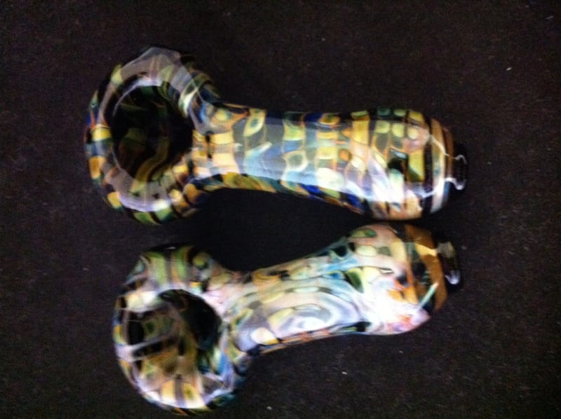 A pair of hand pipes with honeycomb patterning in amber and black