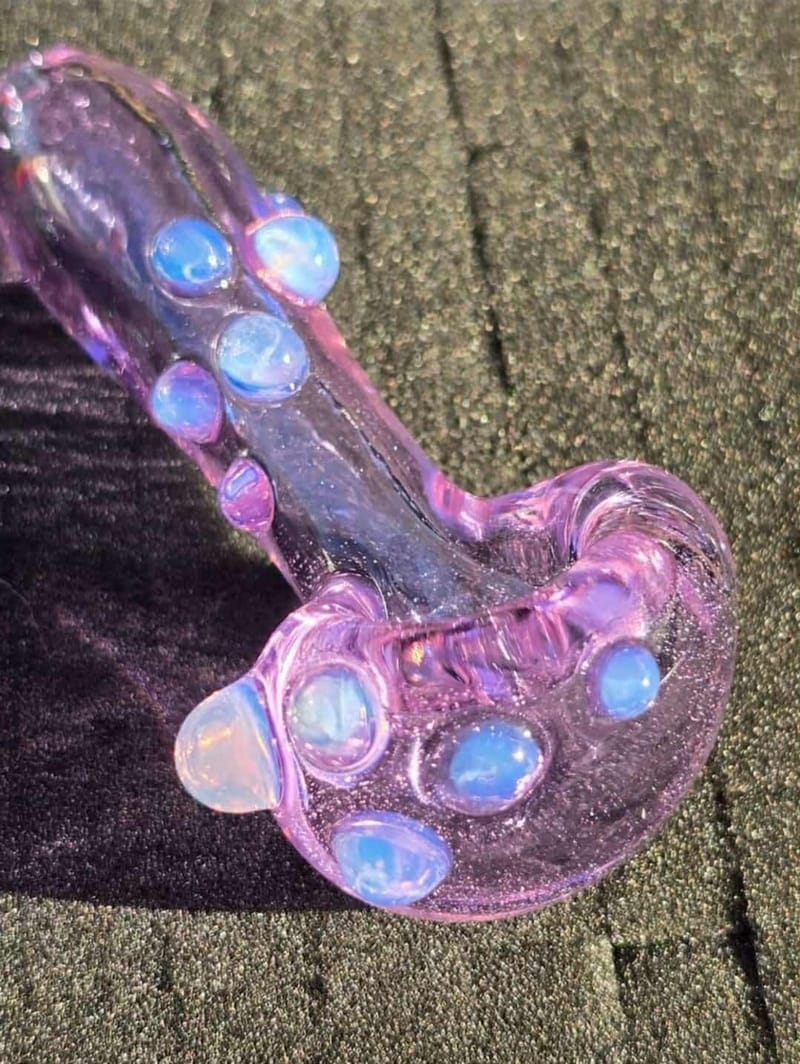 Detail of a pink hand pipe set with pale opal dots