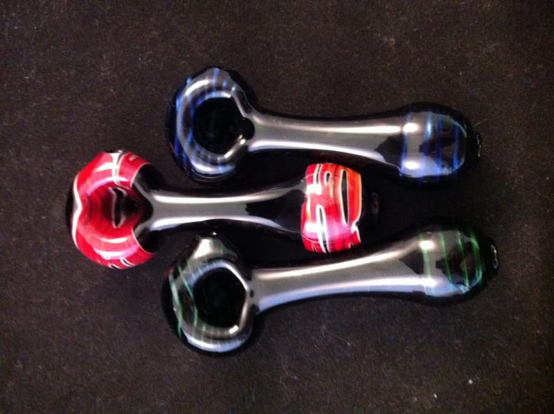 Three hand pipes in red and black on clear glass