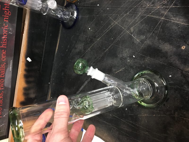 A green percolator water pipe held in one hand