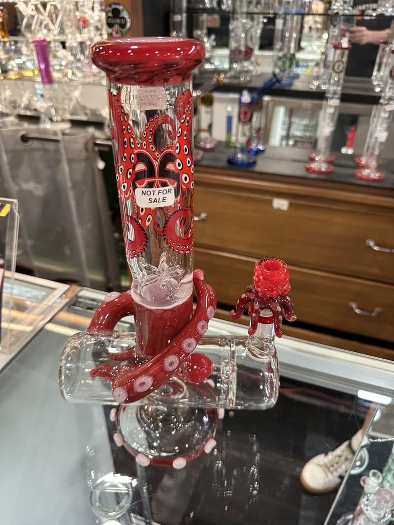 A red glass bubbler worked as an octopus, with tentacles wrapping the base