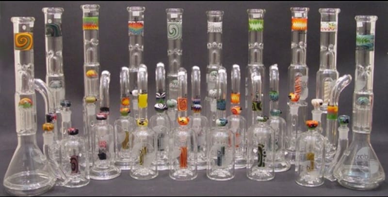 A long row of clear straight-tube water pipes with coloured mouthpiece accents